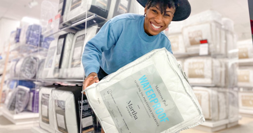 woman holding a mattress pad in a bag