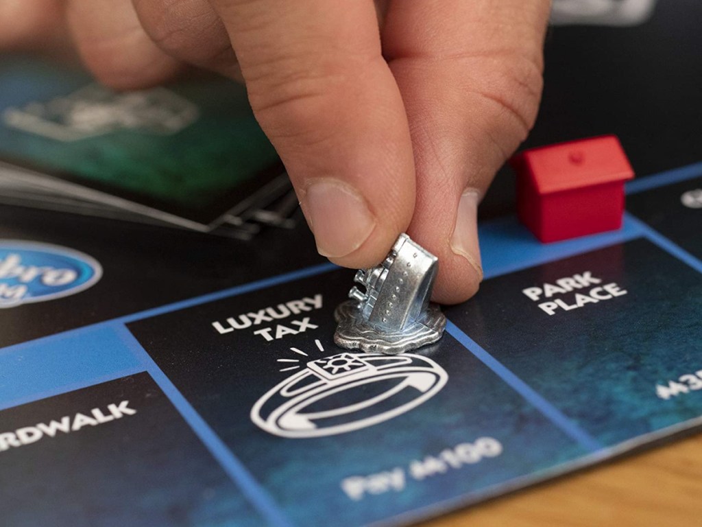 hand putting small figure of sinking boat on board game