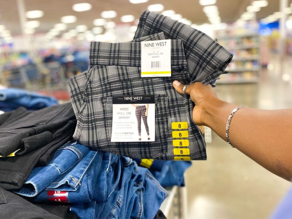 woman holding up Nine West pants