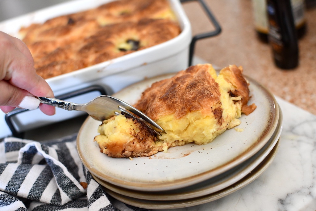 taking slice of bread pudding with croissants 