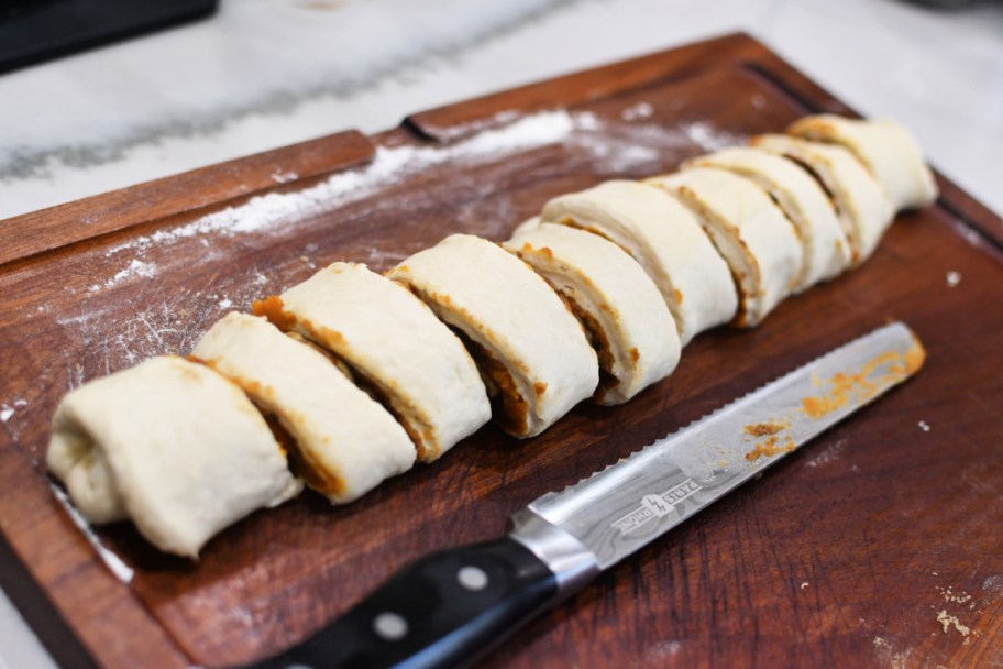 slicing cinnamon rolls before baking