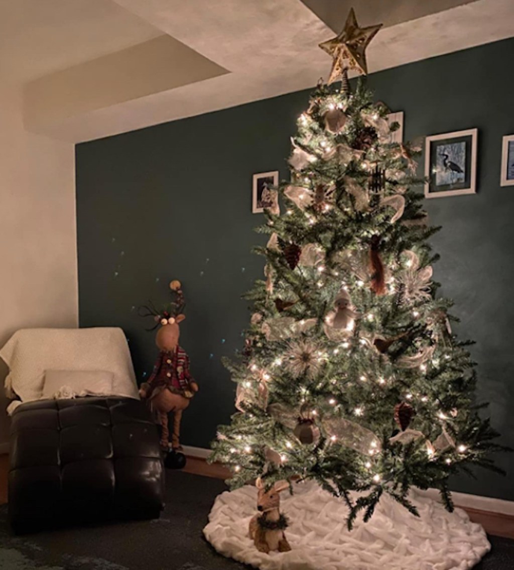 pre lit christmas tree decorated in dark room with lights on