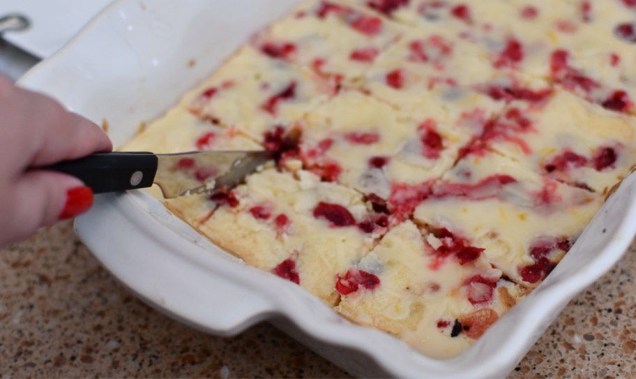 Cutting into a cranberry holiday dessert