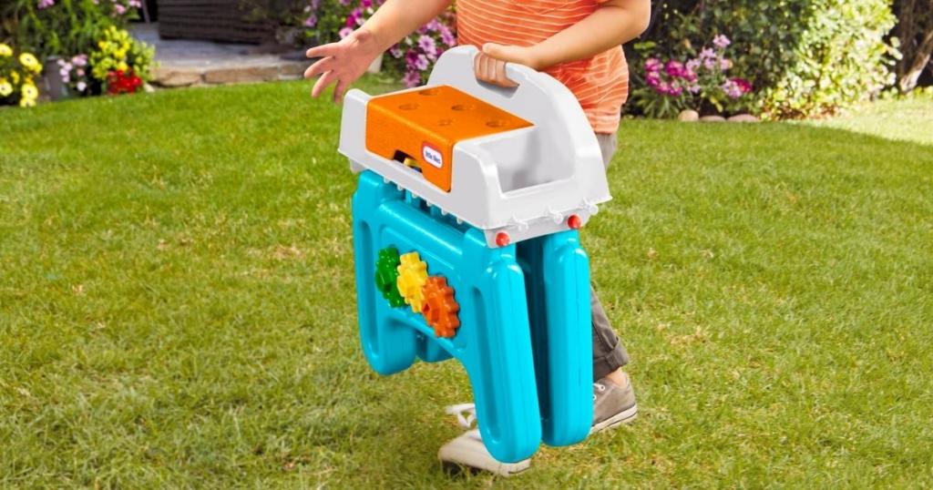 child carrying little tikes first workbench