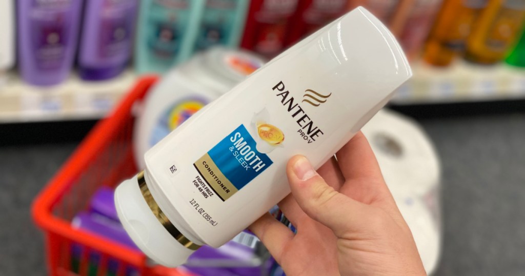 man's hand holding bottle of Pantene shampoo