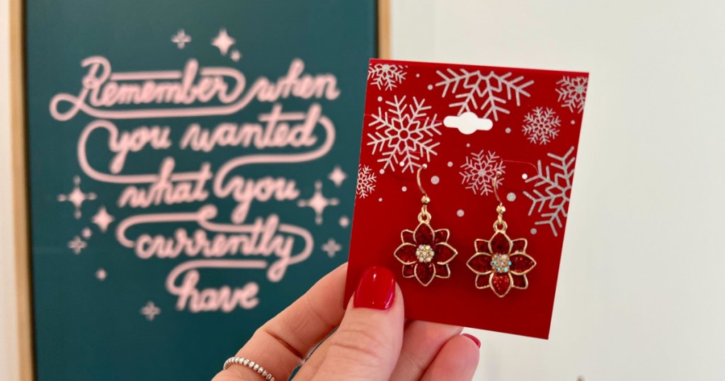 woman holding Poinsettia earrings