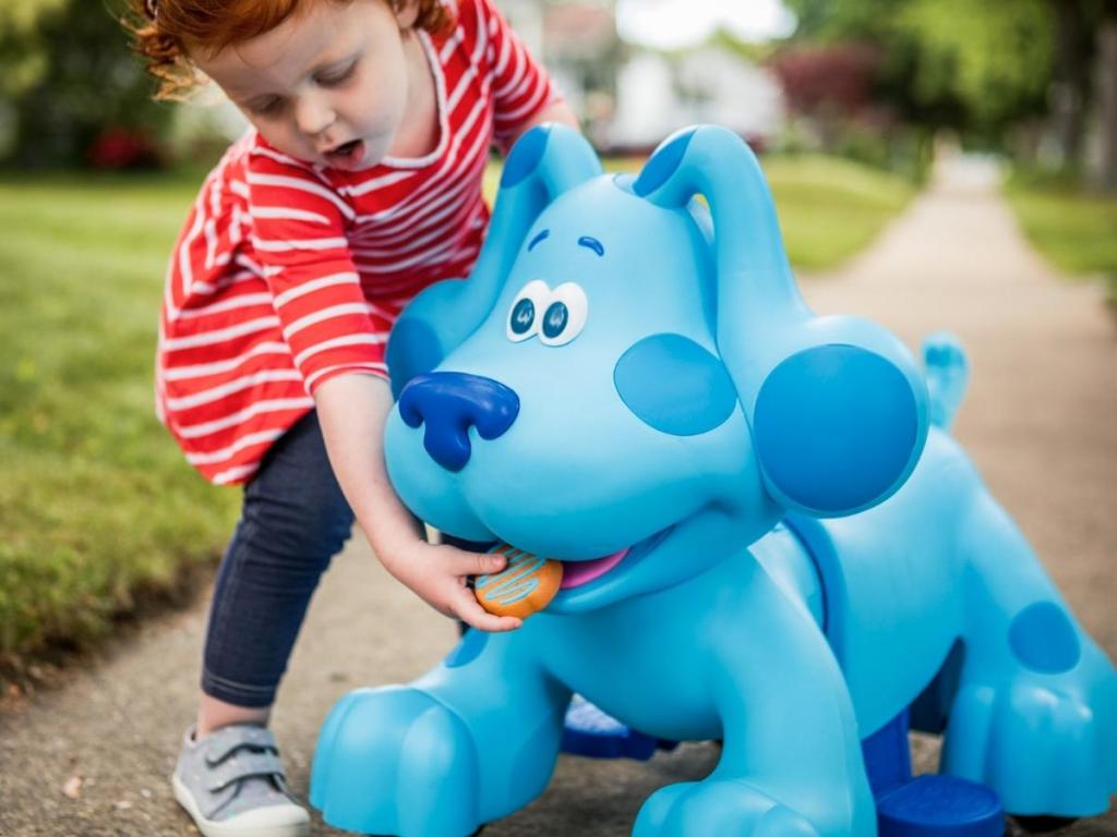 girl feeding rideamals snack time blue ride on toy