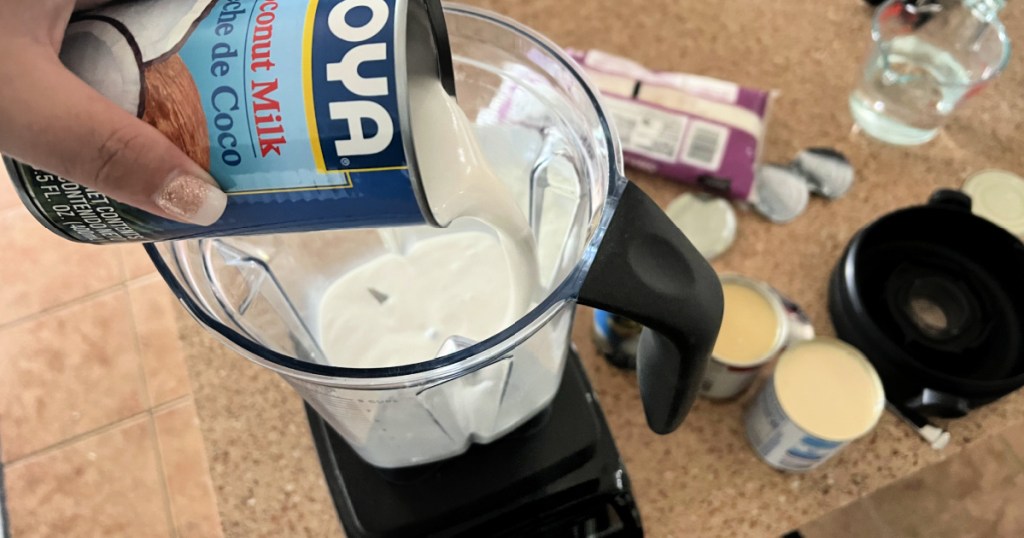 adding coconut milk to coquito