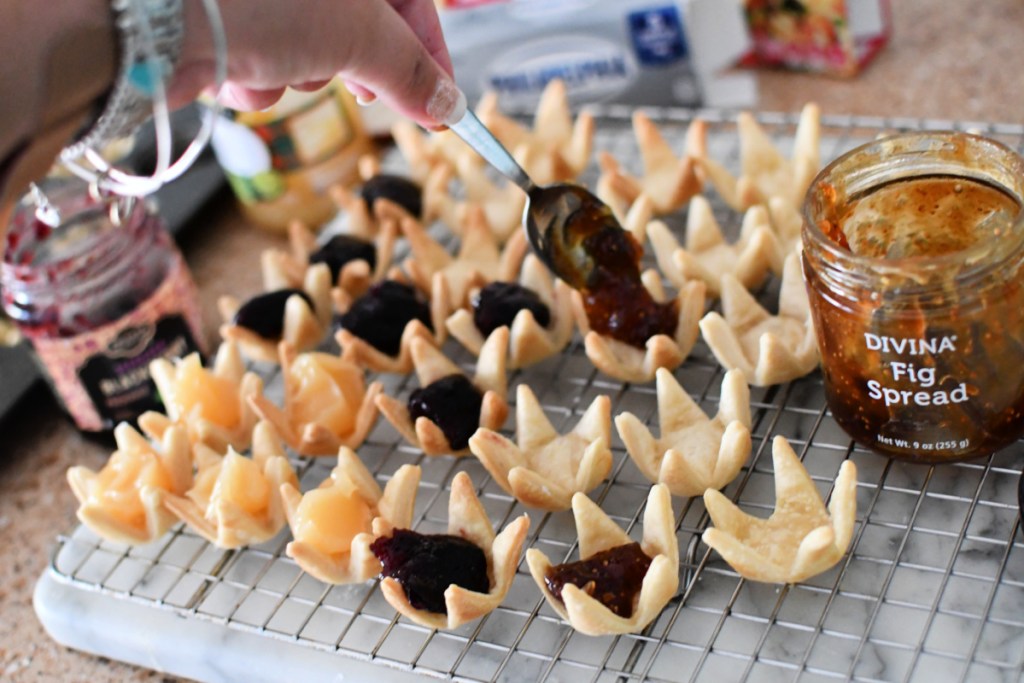 adding fruit spread to mini tarts