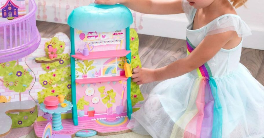 a little girl playing with the rainbow dreamers tree top tea time gazebo