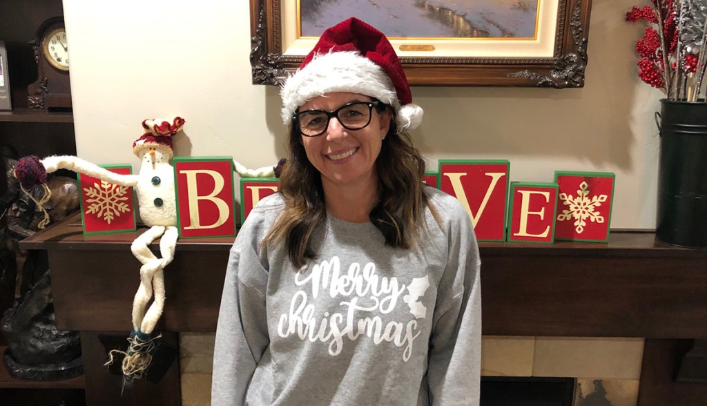 woman wearing Christmas shirt and Santa hat