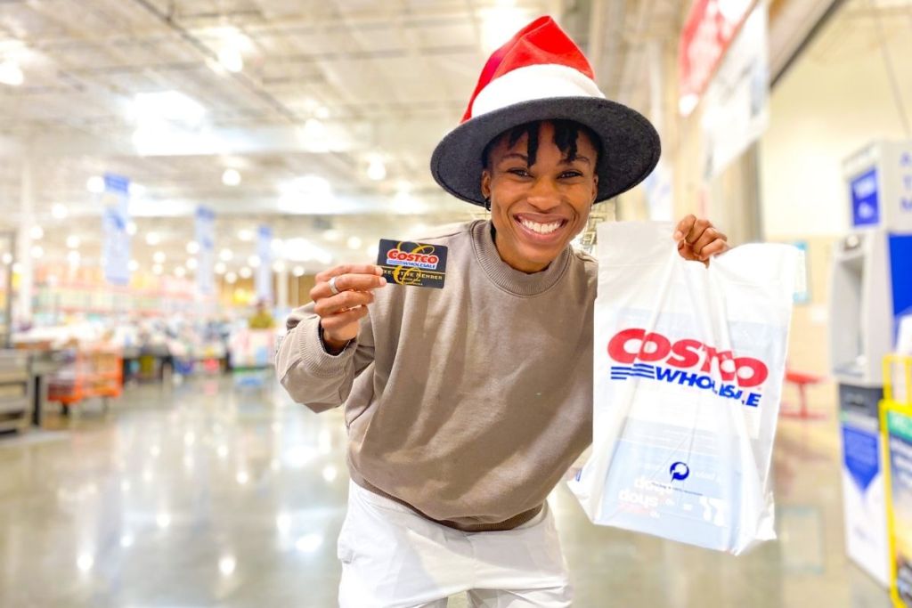 woman holding Costco membership and bag inside Costco