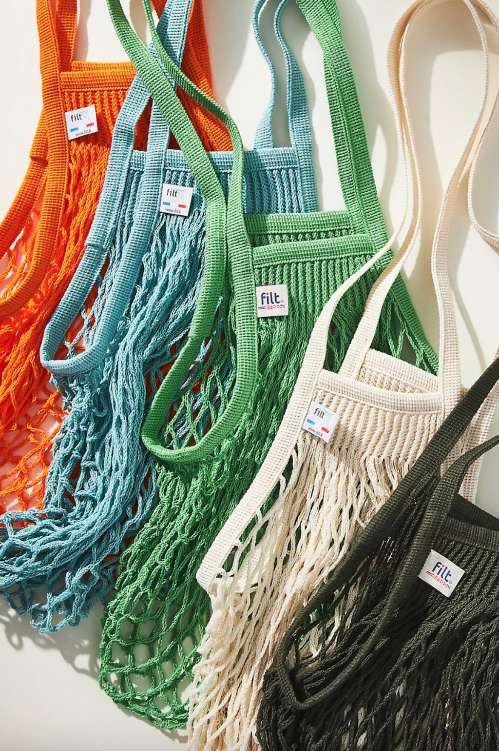 row of colorful mesh produce bags on white background 