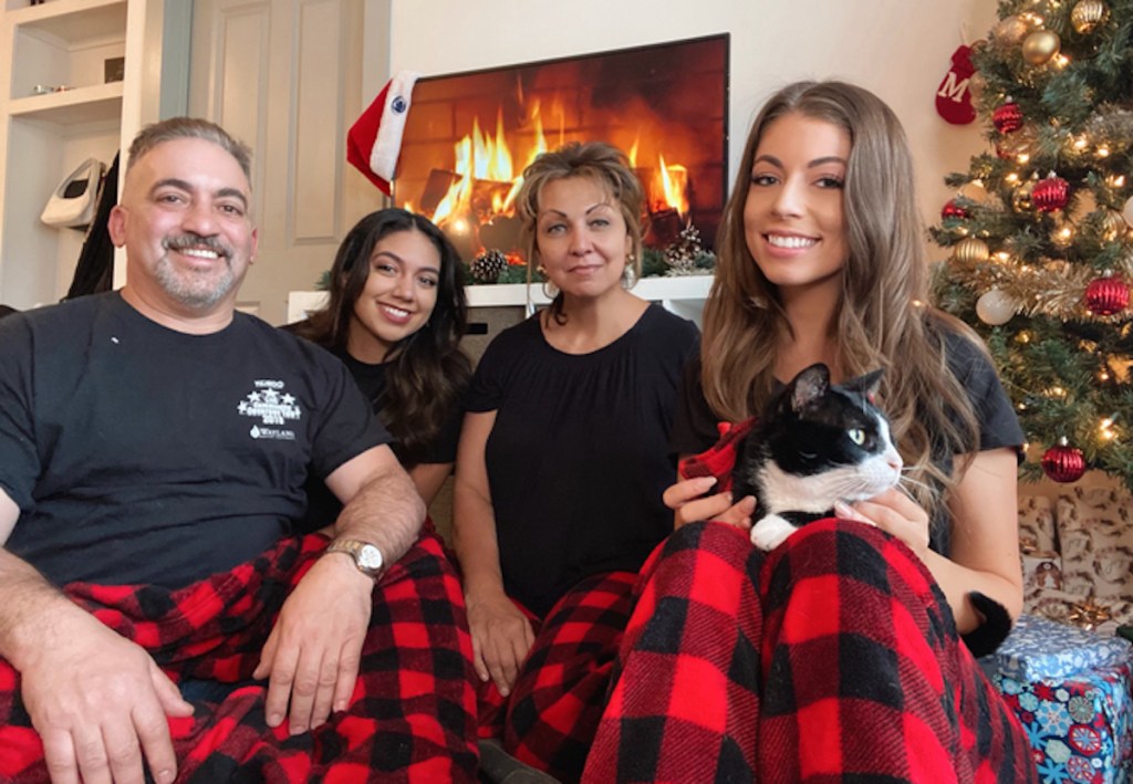 family wearing matching christmas jammies in front of tree