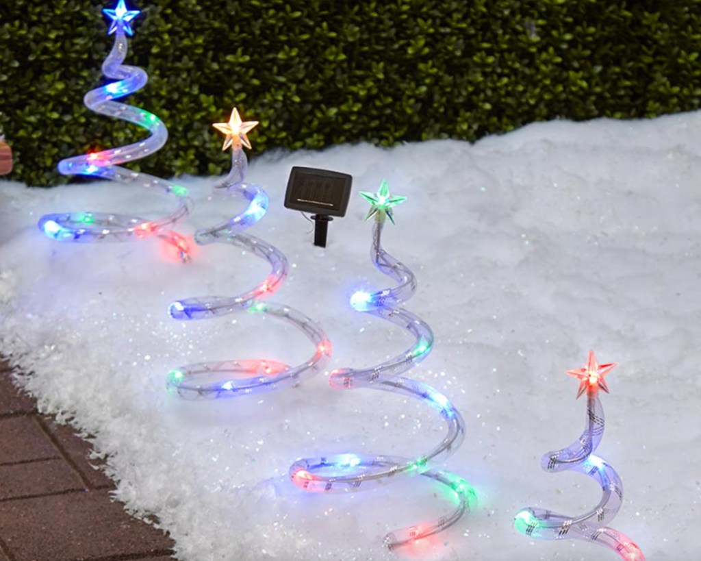 lighted spiral trees in the snow