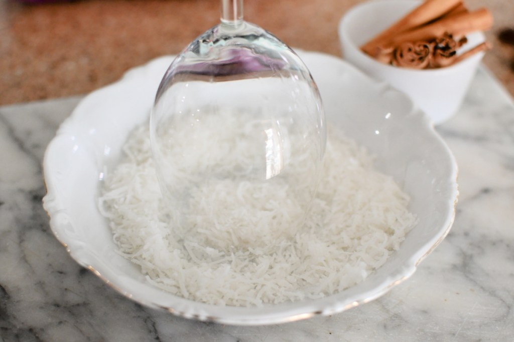 putting dried coconut on the rim of glass