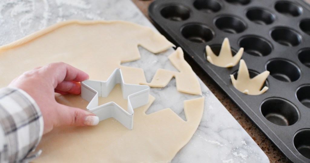 using a star cookie cutter and pie dough to make mini tarts