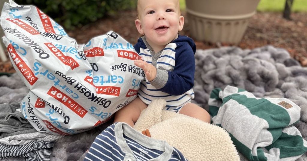 baby holding a Carter's bag