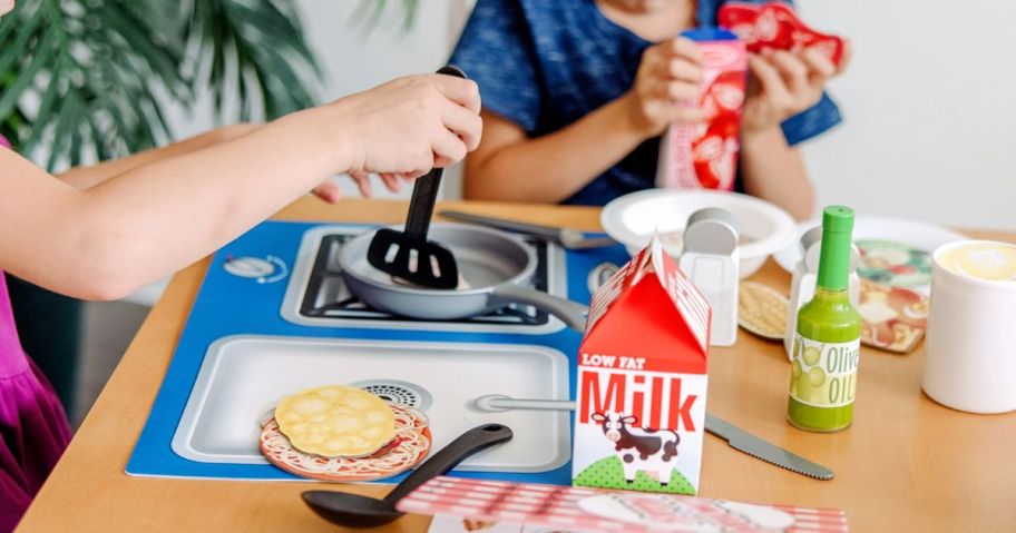 kids playing with a play food and kitchen set