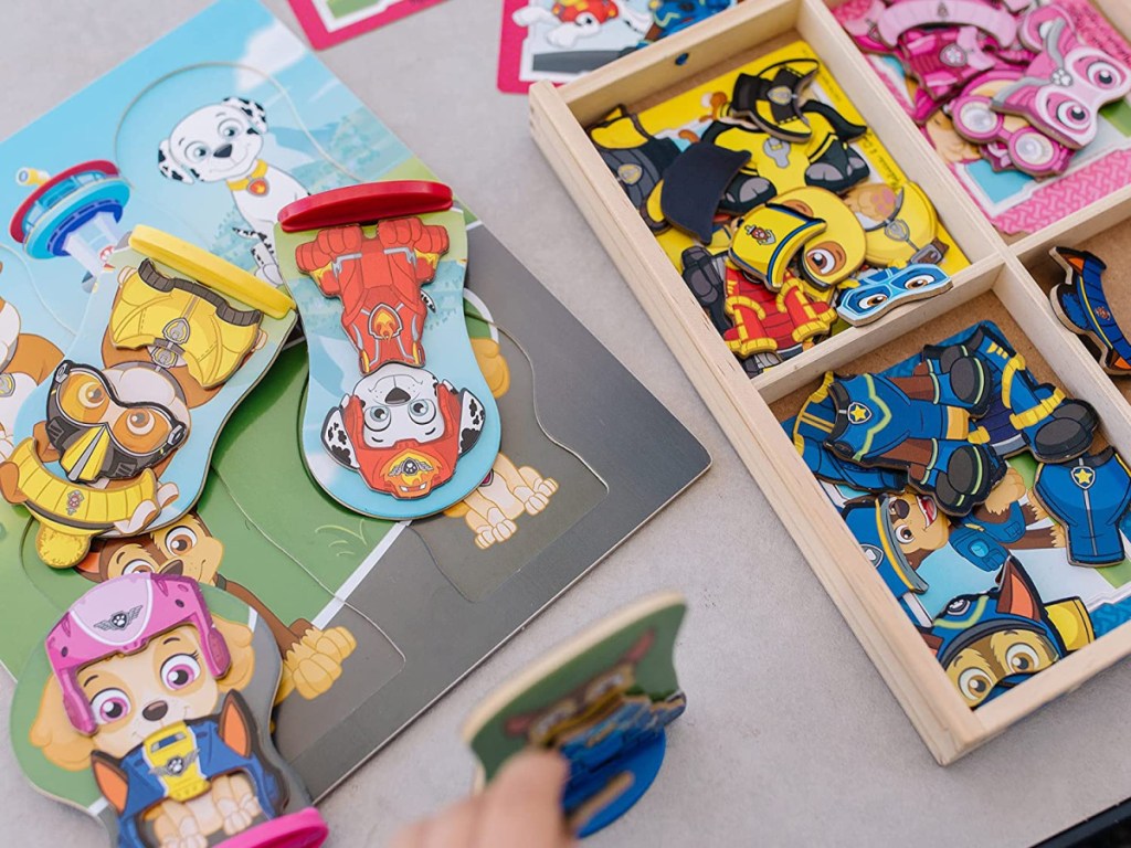 child playing with wooden magnetic set on table