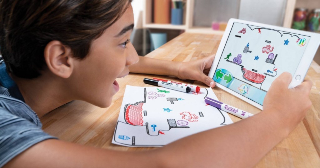 boy playing with mobile video game maker at table