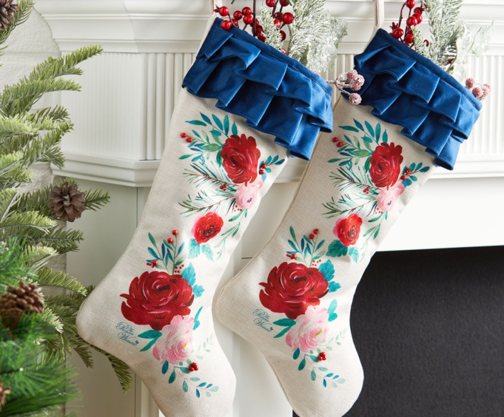 The Pioneer Woman Set of 2 Red Roses Ruffle Christmas Stockings displayed with fruit inside of it