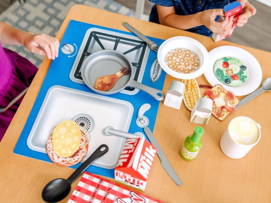 kids playing with a play food and kitchen set