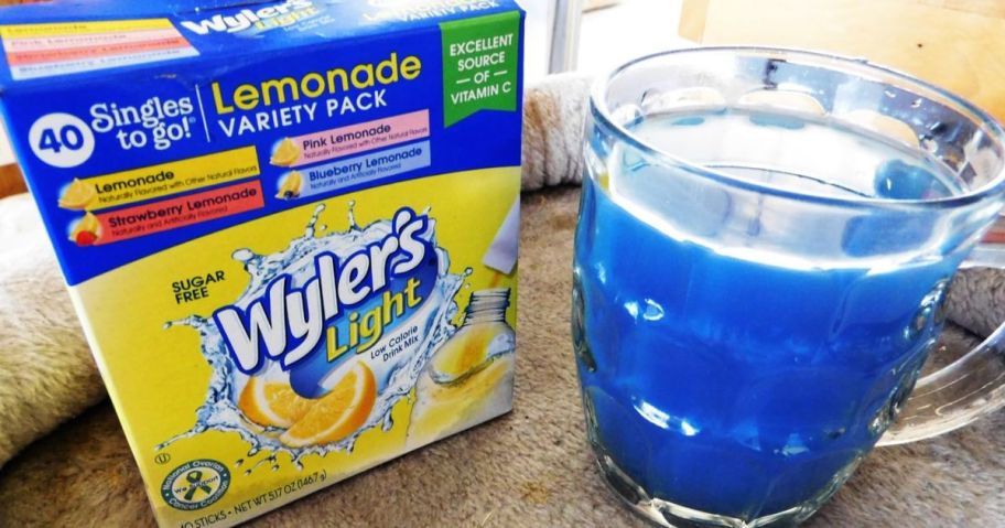 A 40-Count Box of Wyler's Light Lemonade next to a glass of blueberry lemonade