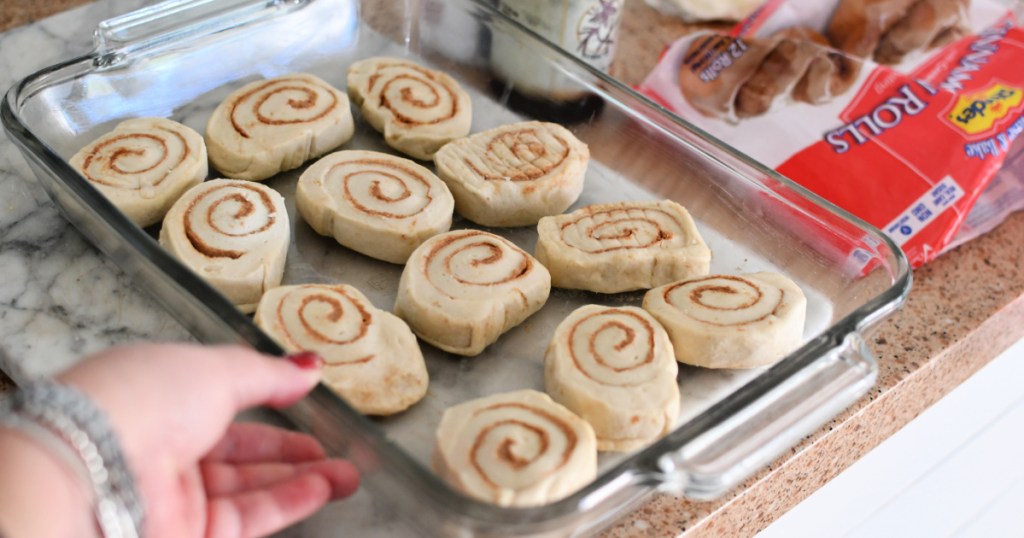 adding frozen cinnamon rolls to baking pan