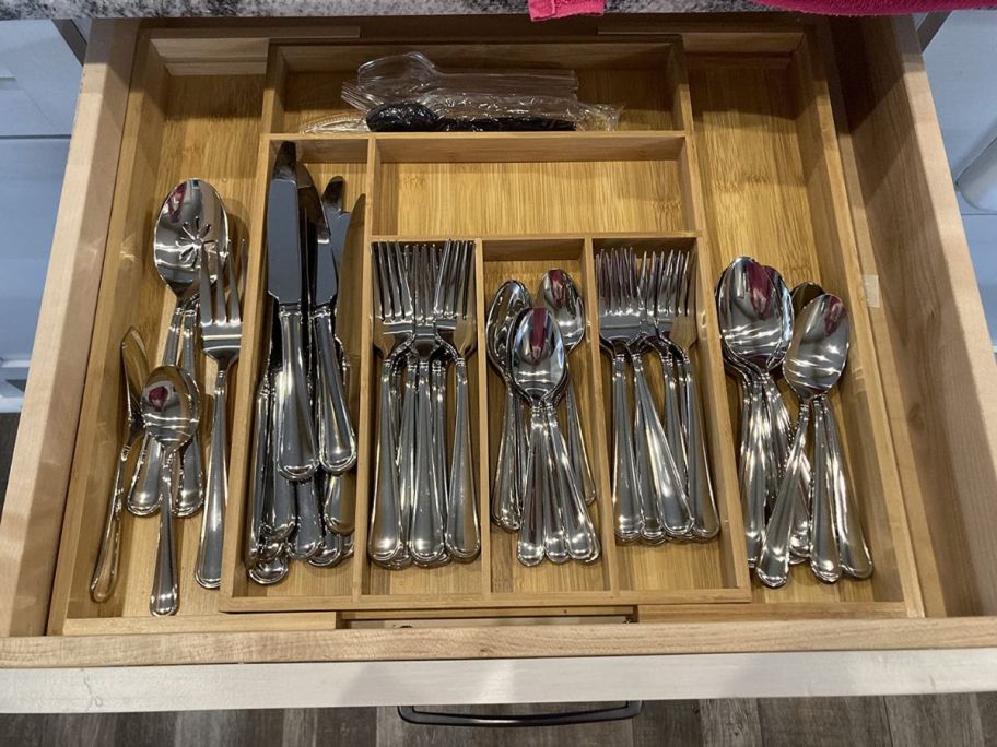 expandable bamboo drawer organizer in a drawer filled with silverware