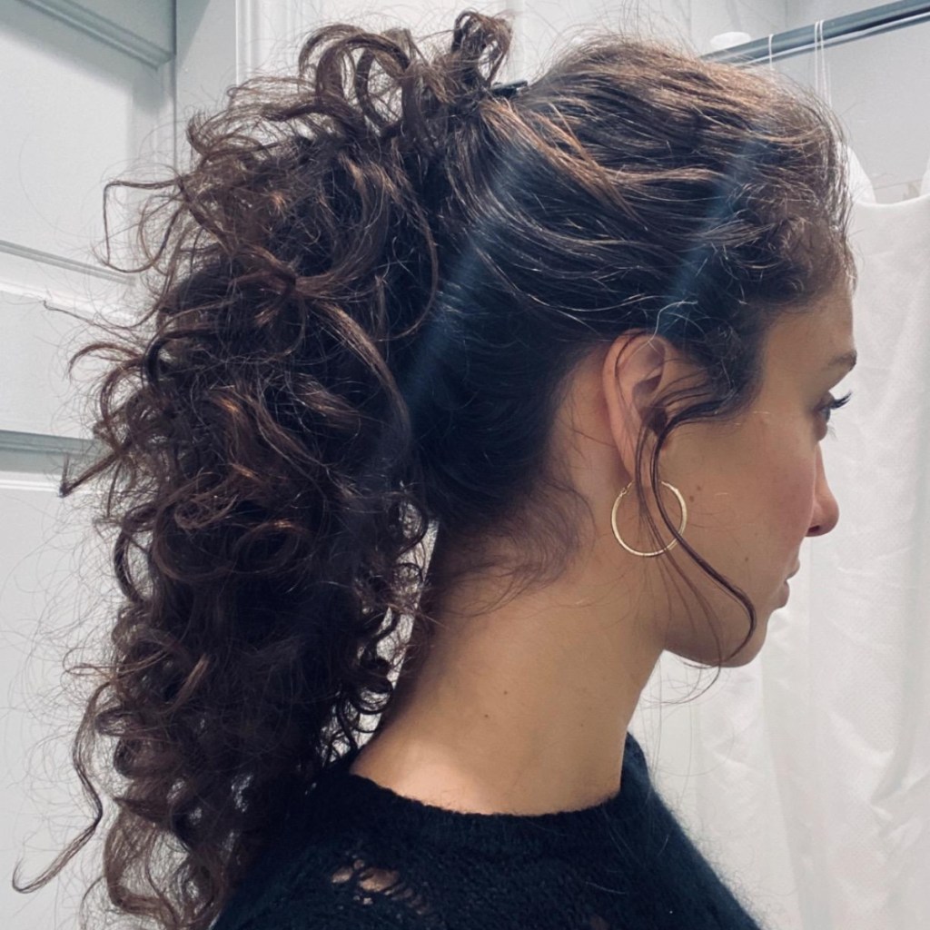 woman with curly hair wearing a banana clip