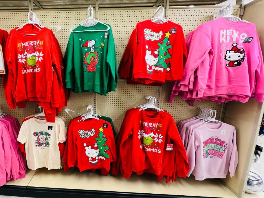 holiday sweatshirts and tees hanging on a display shelf