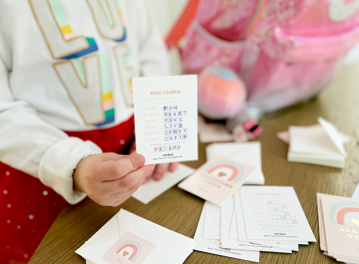 kids hand holding word scramble game 