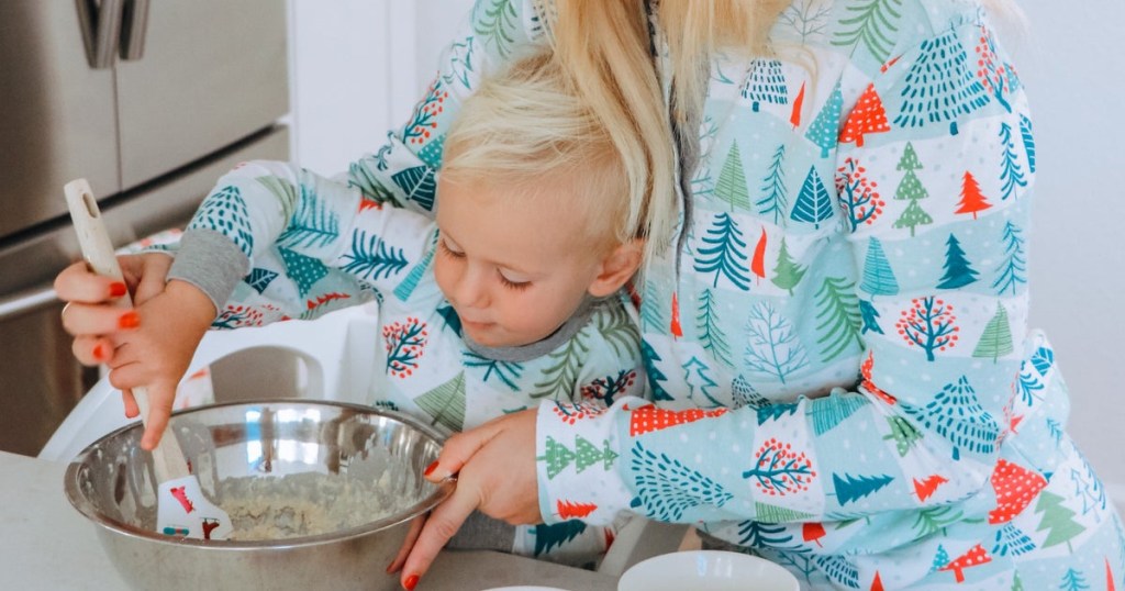 parent and little boy in Christmas pj's making sugar cookies