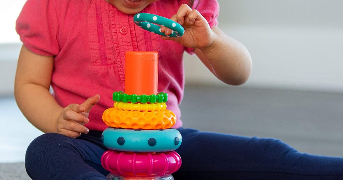 little girl using toy for stacking