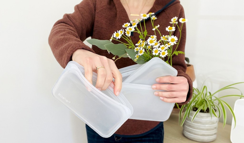 woman holding clear stasher reusable silicone bags