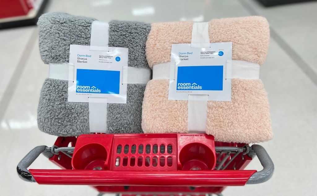 gray and pink sherpa blankets on top of red target cart in middle of store aisle