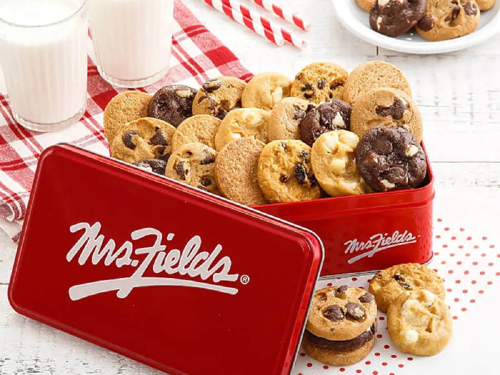 tin of mini cookies and glass of milk on table