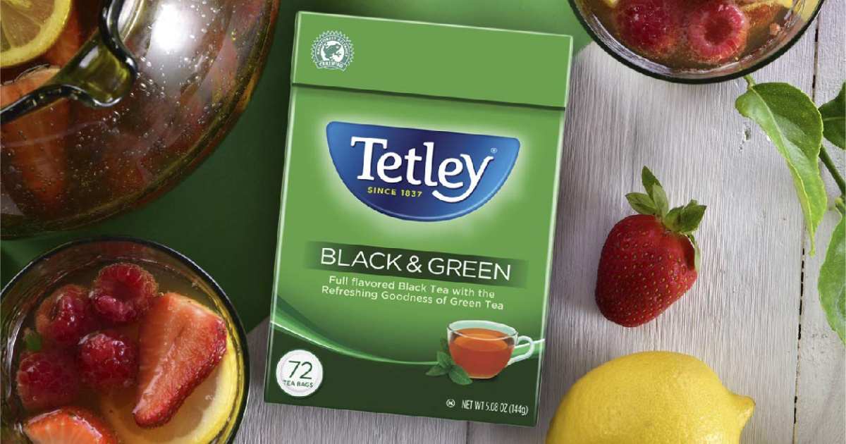 Black & Green Tetley Tea on table among fruit