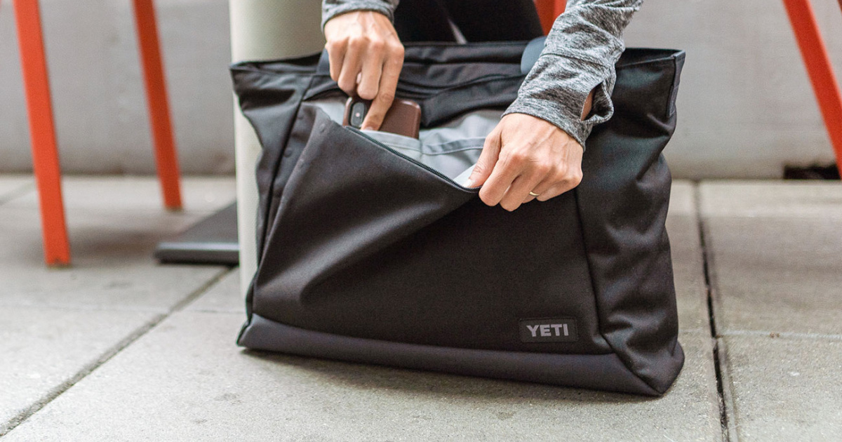 Woman opening a YETI Crossroads Tote Bag 16L