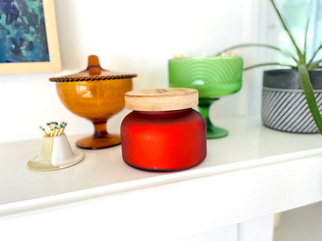 wood topped candle sitting on mantle 