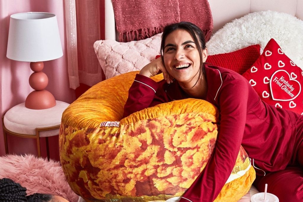 woman laying on KFC chicken sandwich pillow