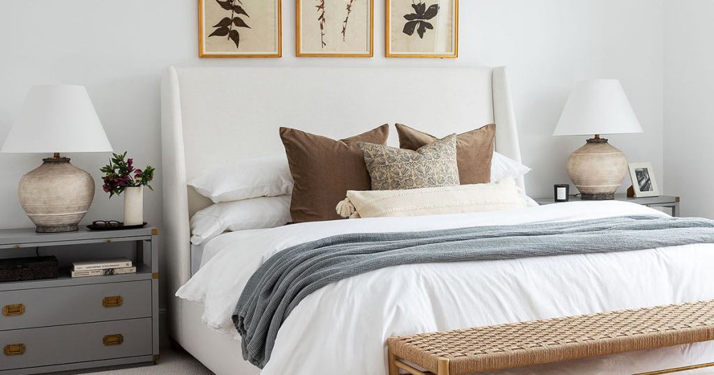 close up of master bed with throw pillows and neutral bedding