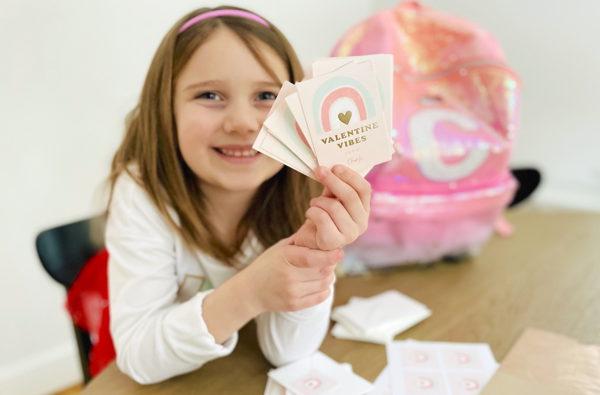 girl holding up stack of valentine vibes valentines day cards