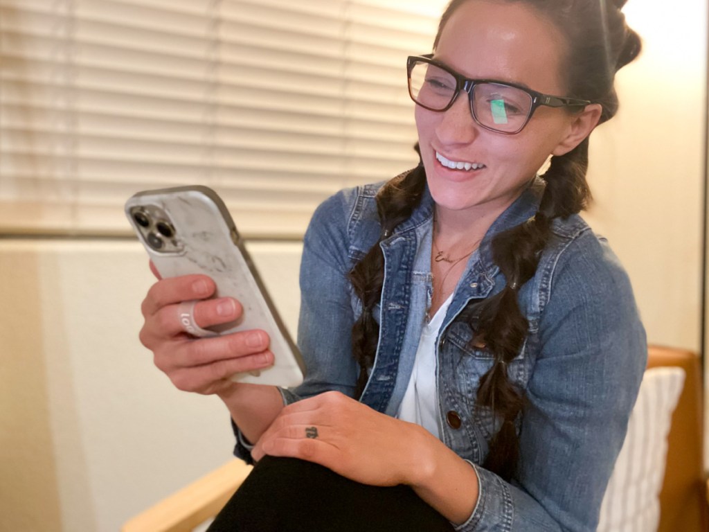 woman holding phone looking at screen