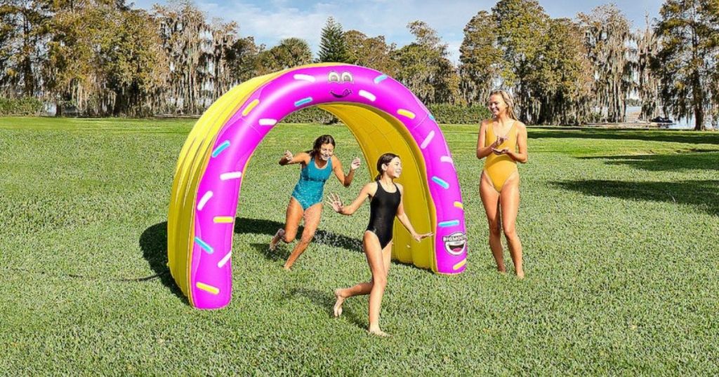 kids running through pink donut sprinkler