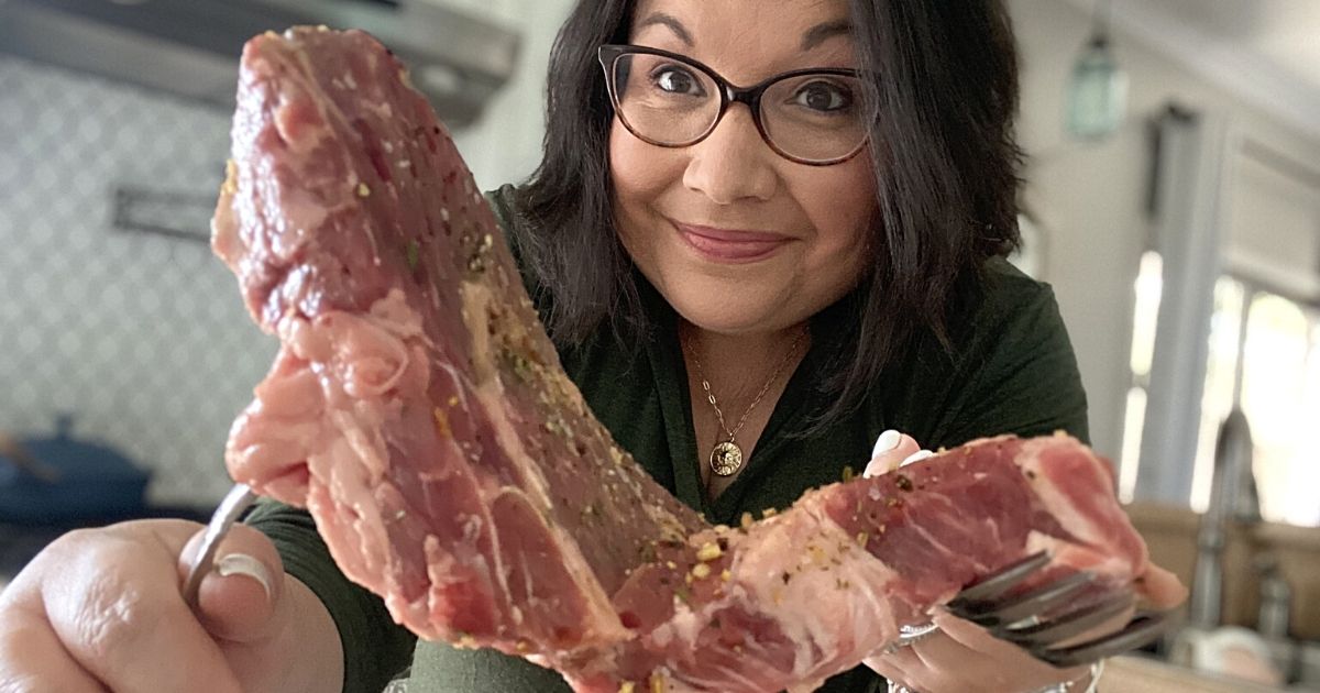 woman holding piece of raw meat