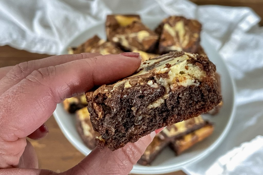 holding a cream cheese brownie side view