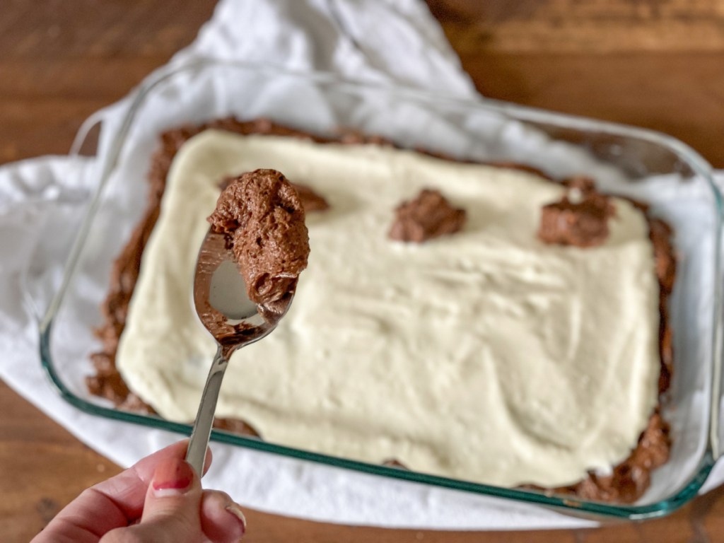 adding brownie batter on top of cream cheese mixture 