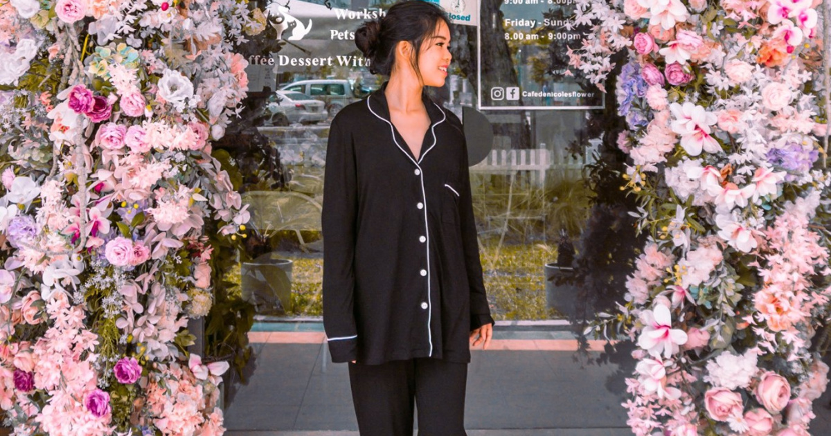 woman in black pajama set standing in front of store